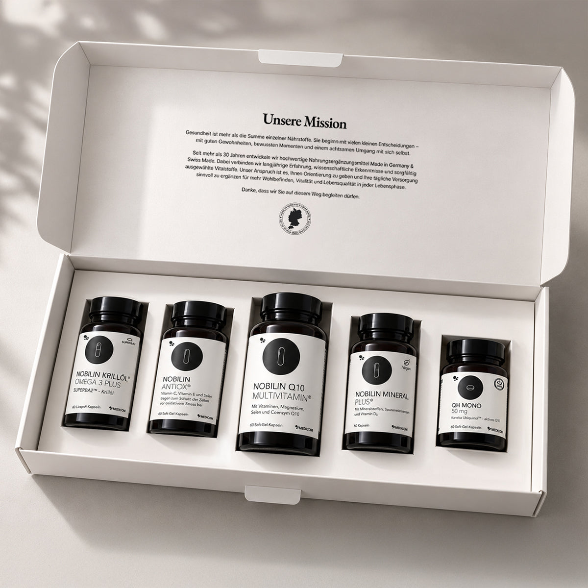 Nobilin Premium Selection Gold in der neuen Meidcom-Box mit fünf Produktdosen. Die Produkte werden elegant, sicher und ordentlich in den Einlegern präsentiert, wenn man die Medicom-Box öffnet.