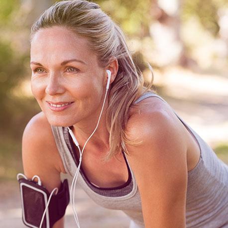 Eine Frau macht Sport und trägt Kopfhörer dabei