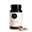 Die Produktdose von Magnesium Citrat Kapseln von Medicom mit zwei Kapseln im Vordergrund