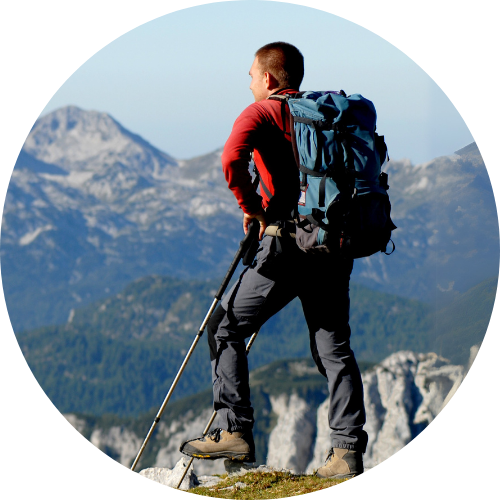 Ein Bergsteiger mit Wanderstöcken und Rucksack unterwegs im Gebirge