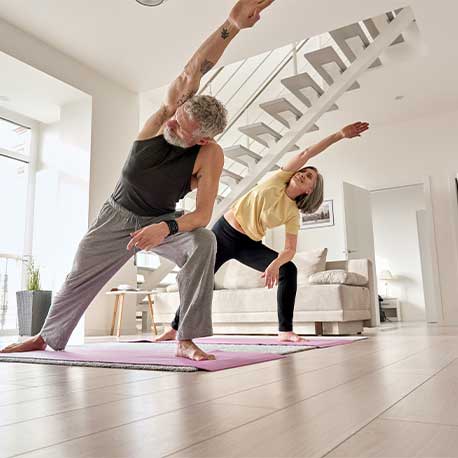 Ein Paar mittleren Alters macht eine Yogaübung